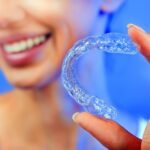 Beautiful Smiling Girl with Tooth Tray (hands Holding Individual Tooth Tray) Methods of Teeth Teeth Whitening and Correction Close-up (blue filter effect)